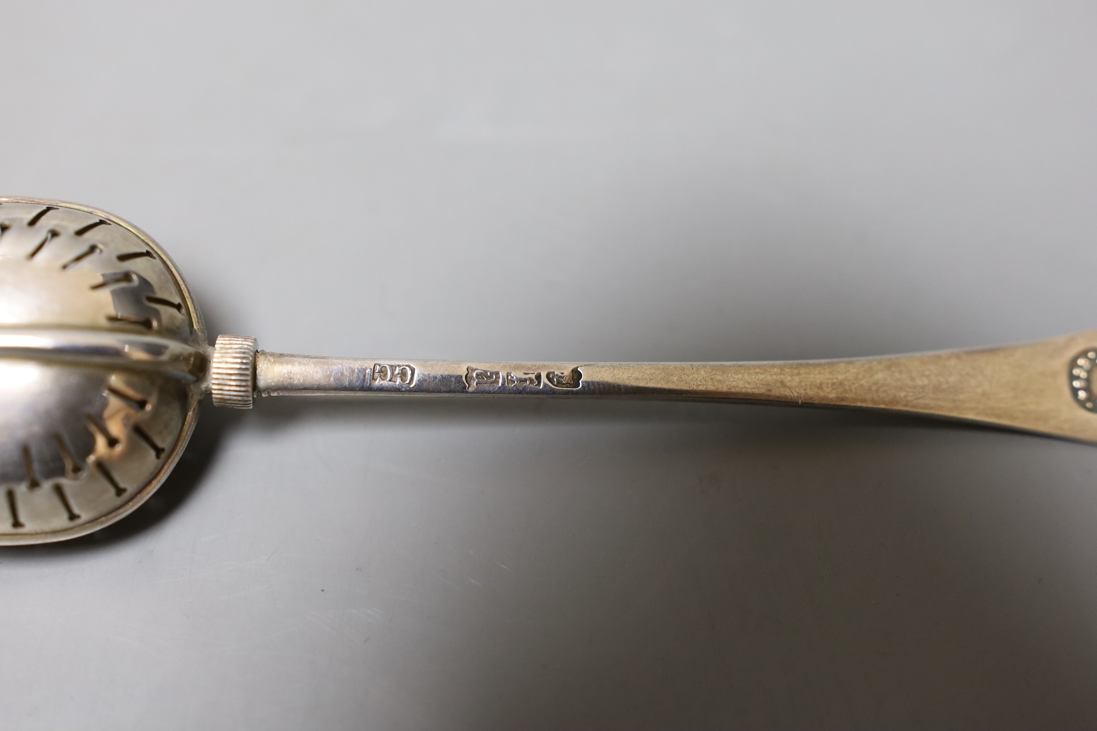 A 19th century continental white metal serving ladle, 36cm and a late Victorian silver tea infuser, gross 216 grams.